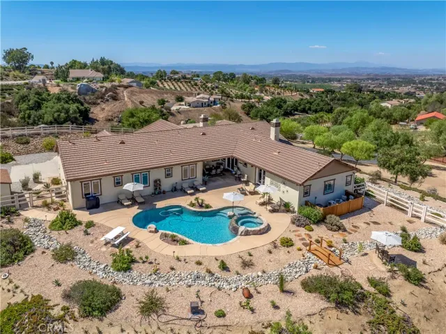 a view of a house with swimming pool and sitting area