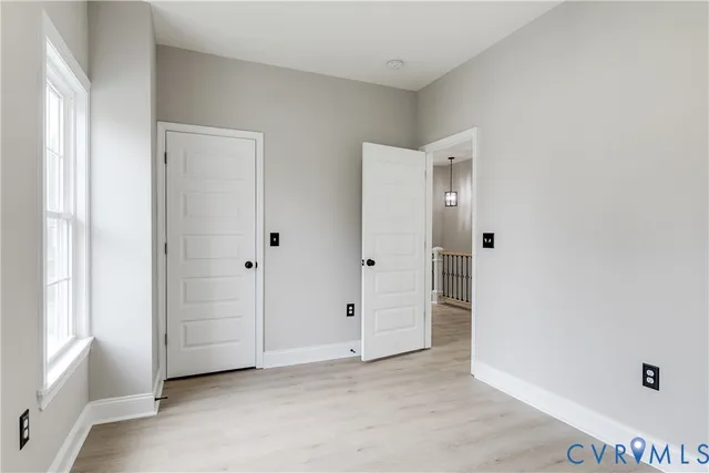 an empty room with windows and closet