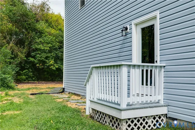a view of a house with a small yard and wooden fence