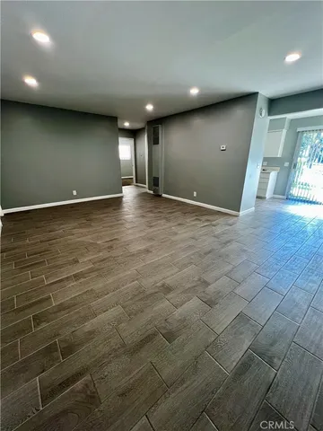 a view of an empty room with wooden floor