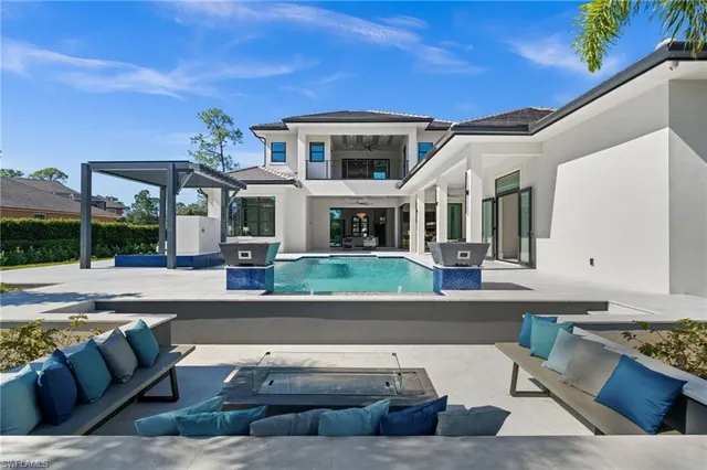 a view of a house with pool and chairs