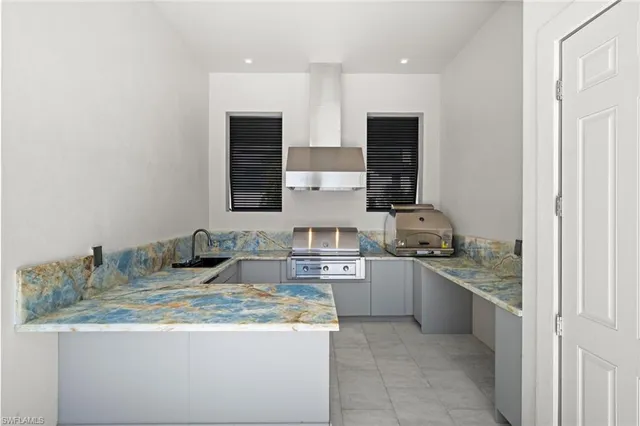 a kitchen with kitchen island a white cabinets and stainless steel appliances
