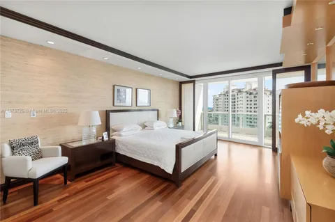 a spacious bedroom with a bed and a wooden floor