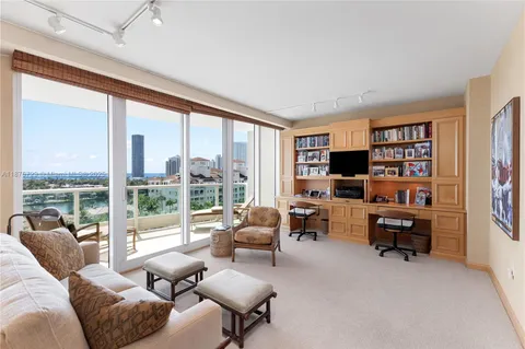 a living room with furniture floor to ceiling window and a flat screen tv