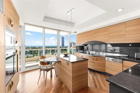 a open kitchen with stainless steel appliances granite countertop a stove top oven a sink and a dining table view