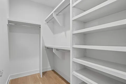 a view of walk in closet with empty racks