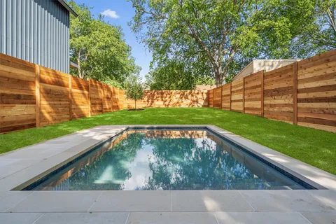 a view of backyard with swimming pool and deck