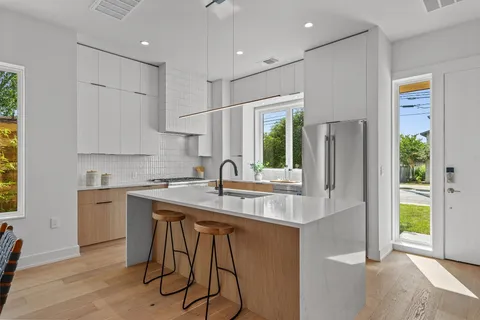 a kitchen with stainless steel appliances granite countertop a sink a stove and a refrigerator