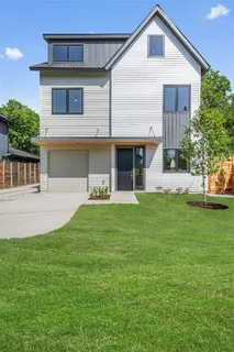 a front view of a house with a yard and trees
