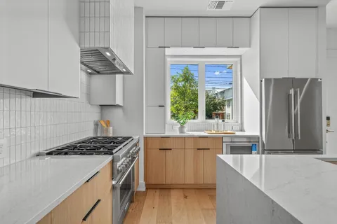 a kitchen with stainless steel appliances a sink stove and refrigerator