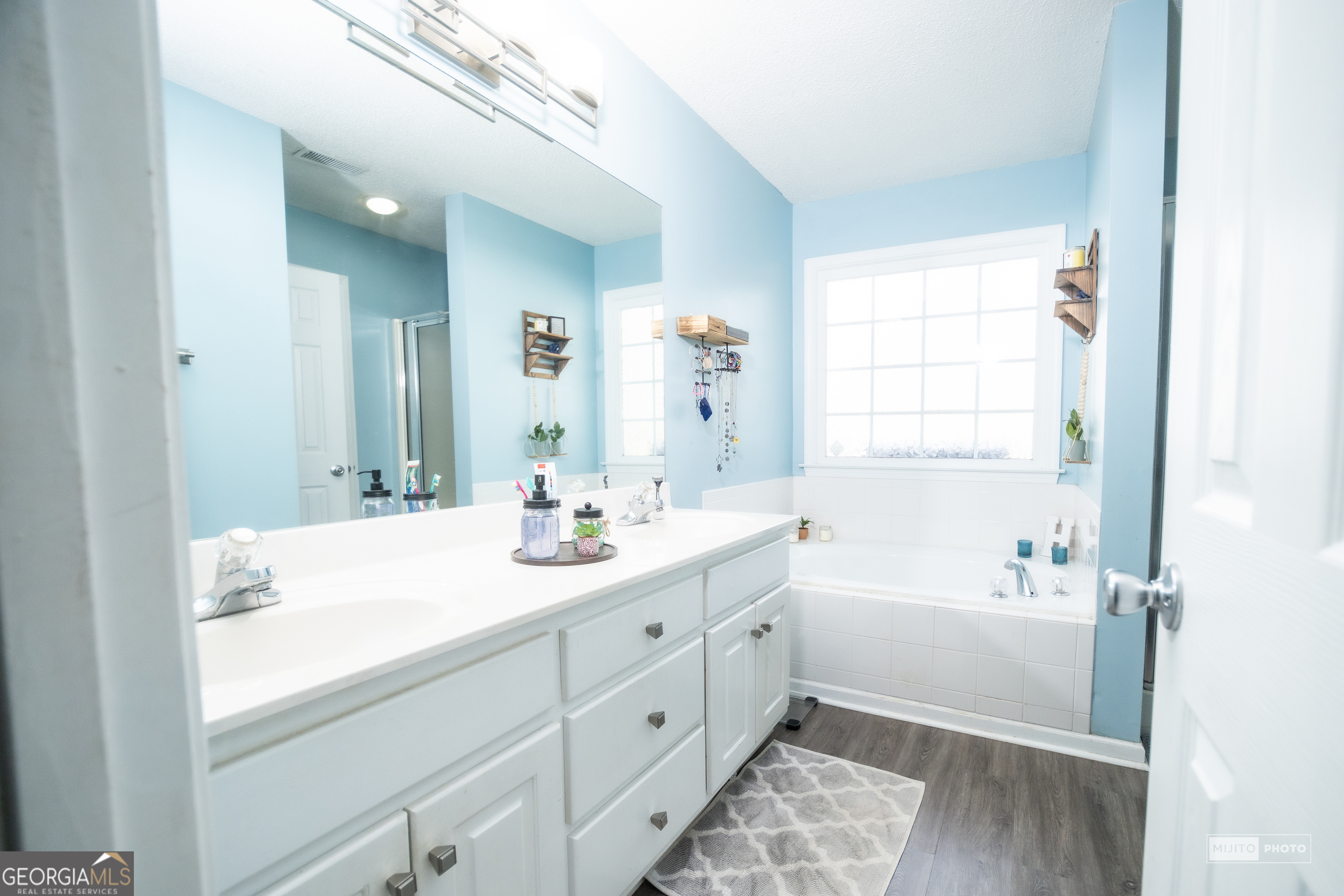124 Austin Way Jefferson, GA 30549 - Photo 19 of 32 a spacious bathroom with double vanity a mirror a bathtub and a shower