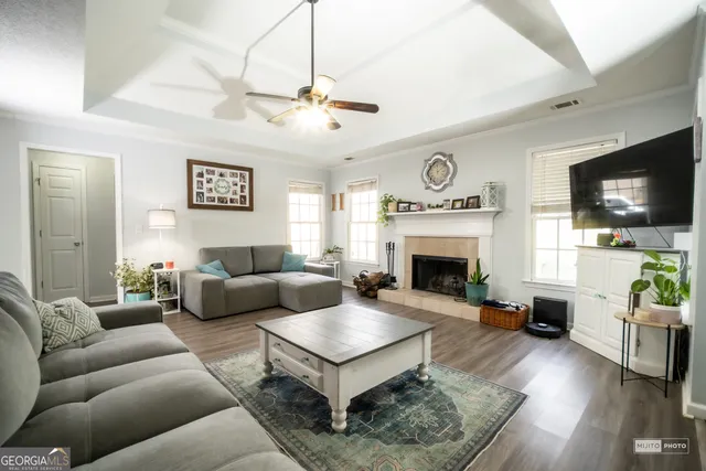 a living room with furniture a flat screen tv and a fireplace