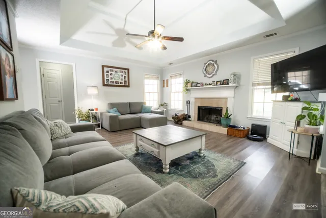 a living room with furniture a fireplace and a flat screen tv