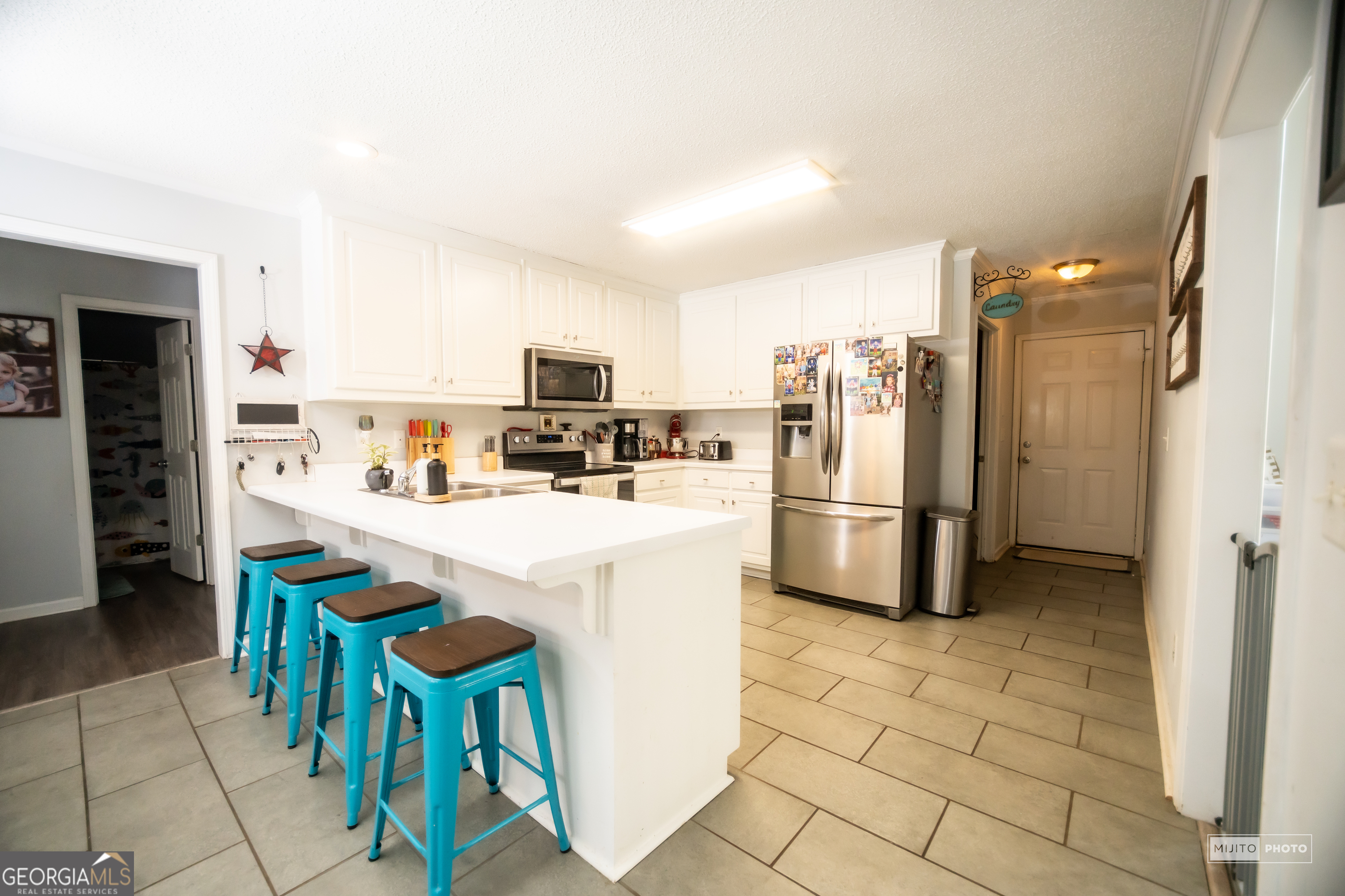 124 Austin Way Jefferson, GA 30549 - Photo 9 of 32 a kitchen with stainless steel appliances a refrigerator a stove a sink a dining table and chairs