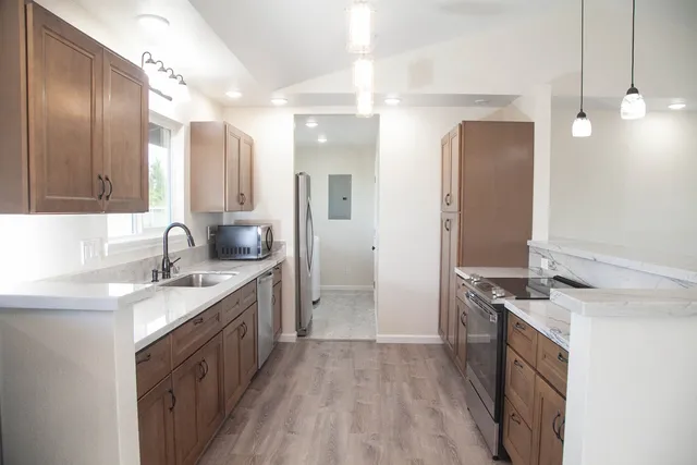 a kitchen with a sink stove top oven and refrigerator