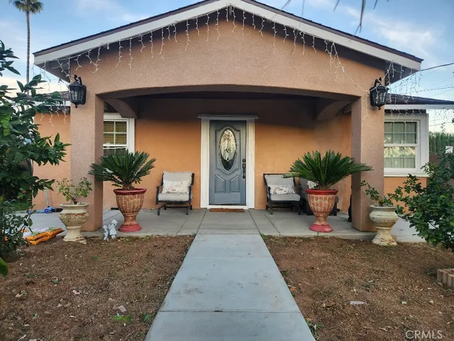 a view of a house with potted plants and a table