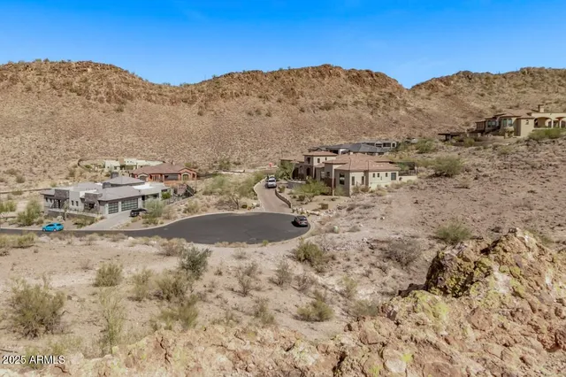 a view of a dry field with mountains in the background