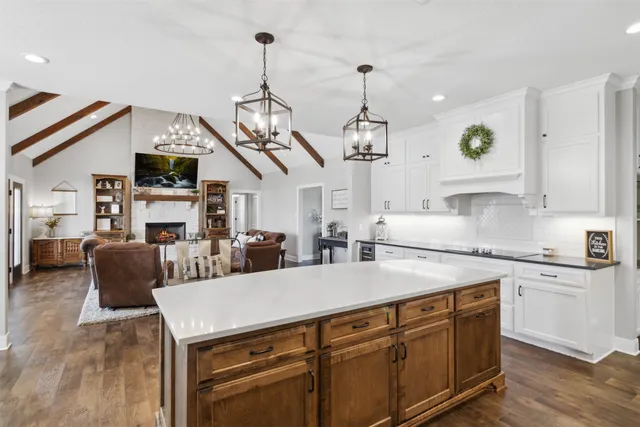 a kitchen with stainless steel appliances granite countertop a sink a stove and a wooden floors