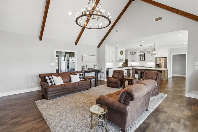 a living room with furniture a dining table and chairs with wooden floor