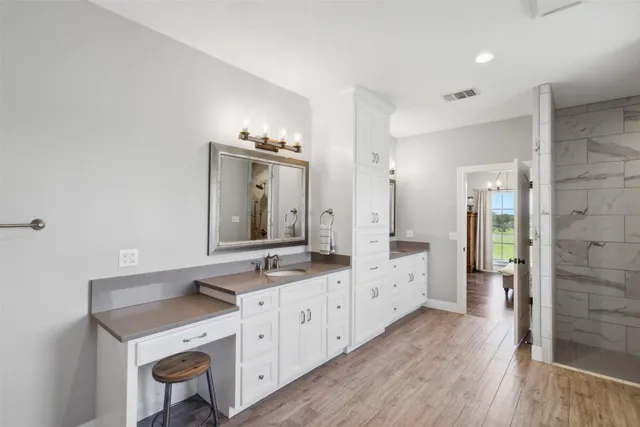 a spacious bathroom with a double vanity sink a mirror and a shower