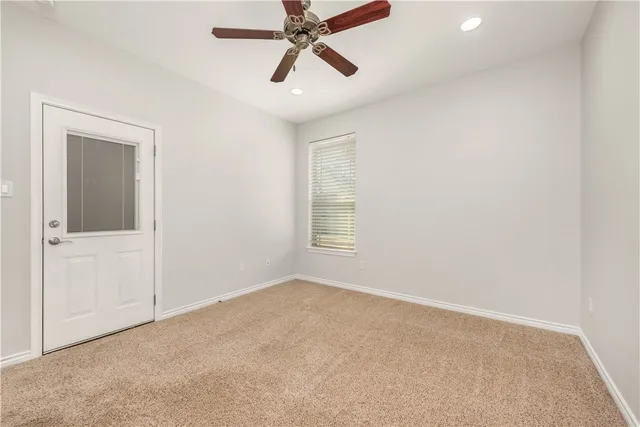 an empty room with closet and windows