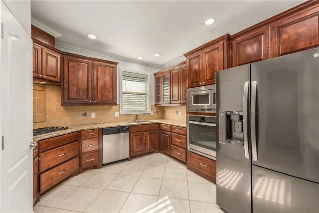 a kitchen with stainless steel appliances granite countertop a refrigerator and a stove top oven