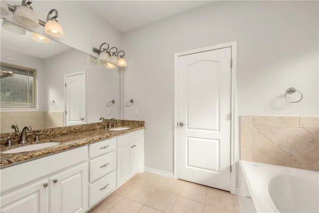 a spacious bathroom with a granite countertop sink a toilet a mirror and vanity
