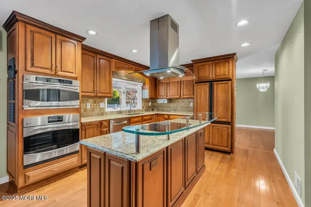 a kitchen with stainless steel appliances granite countertop a sink and a refrigerator