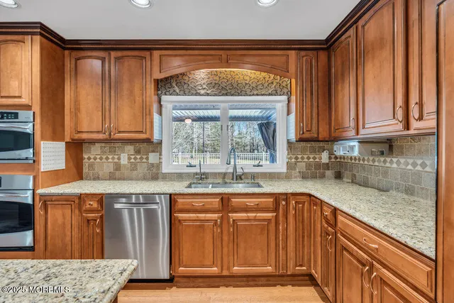 a kitchen with granite countertop a sink and cabinets