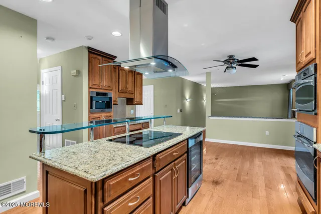 a kitchen with stainless steel appliances granite countertop a sink and a refrigerator