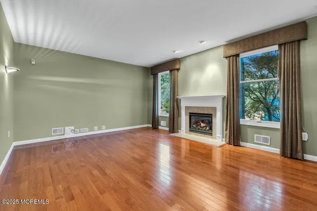 a view of an empty room with a fireplace and a window