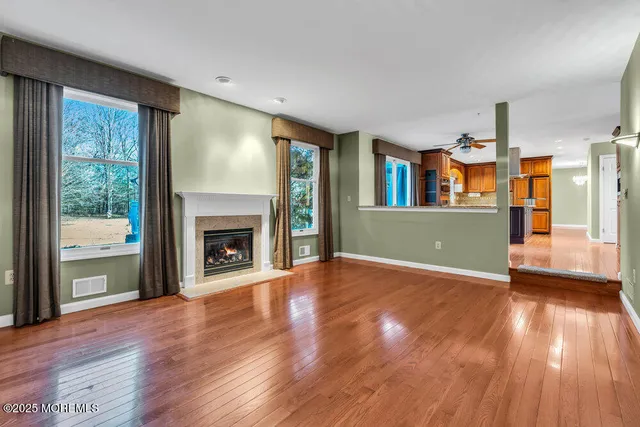 a view of a livingroom with wooden floor and a fireplace