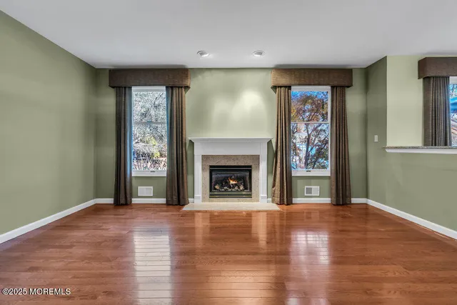 a view of a livingroom with wooden floor and a fireplace