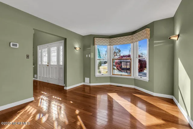 a view of an empty room with bathroom and a window