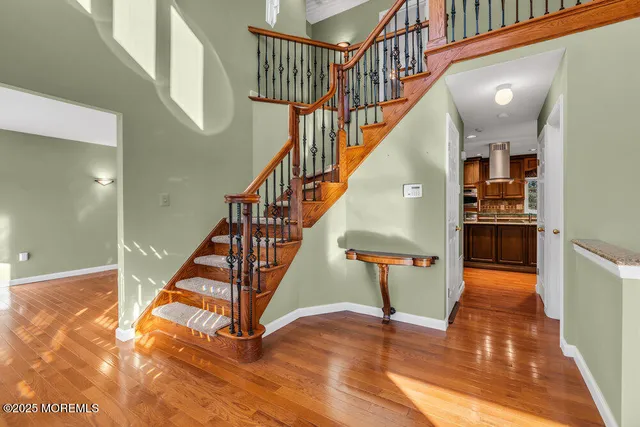 a view of empty room with wooden floor and ceiling fan