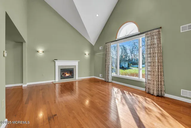 a view of an empty room with a fireplace and a window