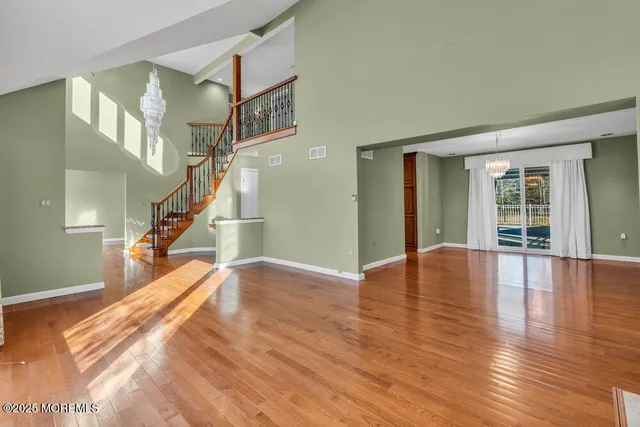 a view of empty room with wooden floor and floor to ceiling window