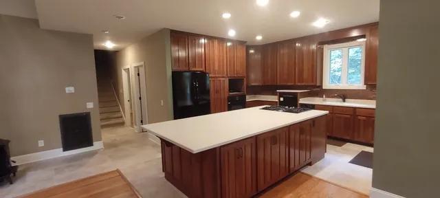 a kitchen with kitchen island a sink stove and refrigerator