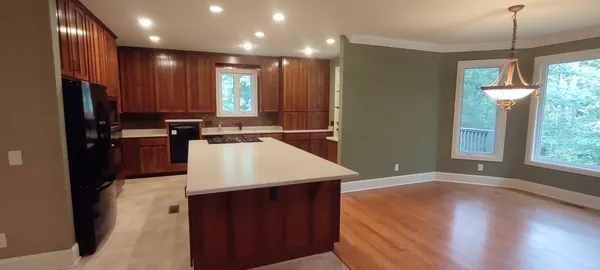 a kitchen with kitchen island a counter top space appliances and a window