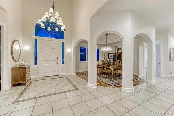 an entryway with a chandelier and livingroom view