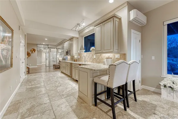 a large white kitchen with kitchen island a sink stainless steel appliances and cabinets