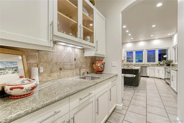 a kitchen with stainless steel appliances granite countertop a sink and white cabinets