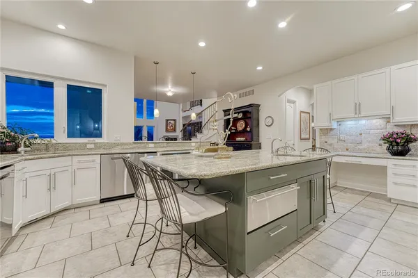 a kitchen with stainless steel appliances kitchen island granite countertop a sink and cabinets