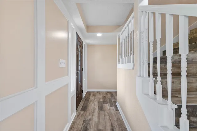 a view of a hallway with wooden floor and entryway