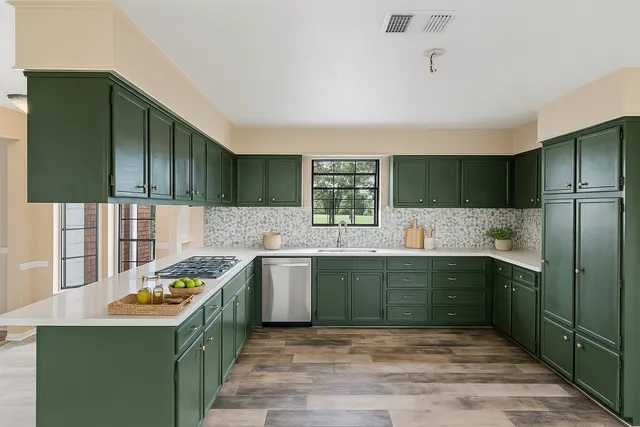 a kitchen with stainless steel appliances granite countertop a sink and a stove