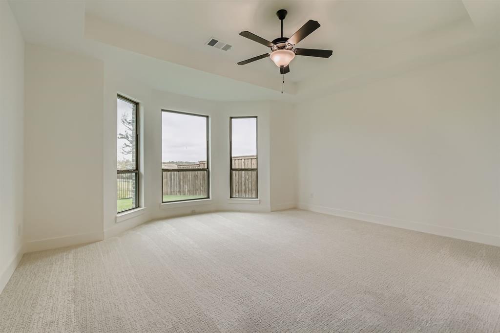 150 Longhorn Bend Rhome, TX 76078 - Photo 11 of 28 Empty room with a raised ceiling, light colored carpet, and a ceiling fan
