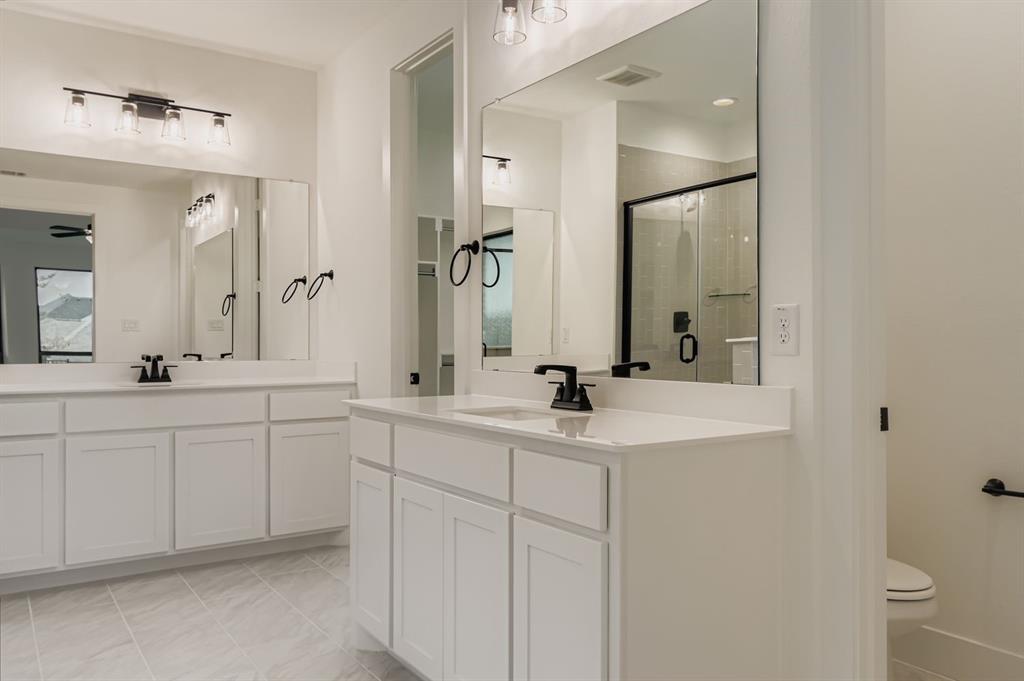 150 Longhorn Bend Rhome, TX 76078 - Photo 14 of 28 Full bath with a stall shower, light tile patterned floors, two vanities, and ceiling fan