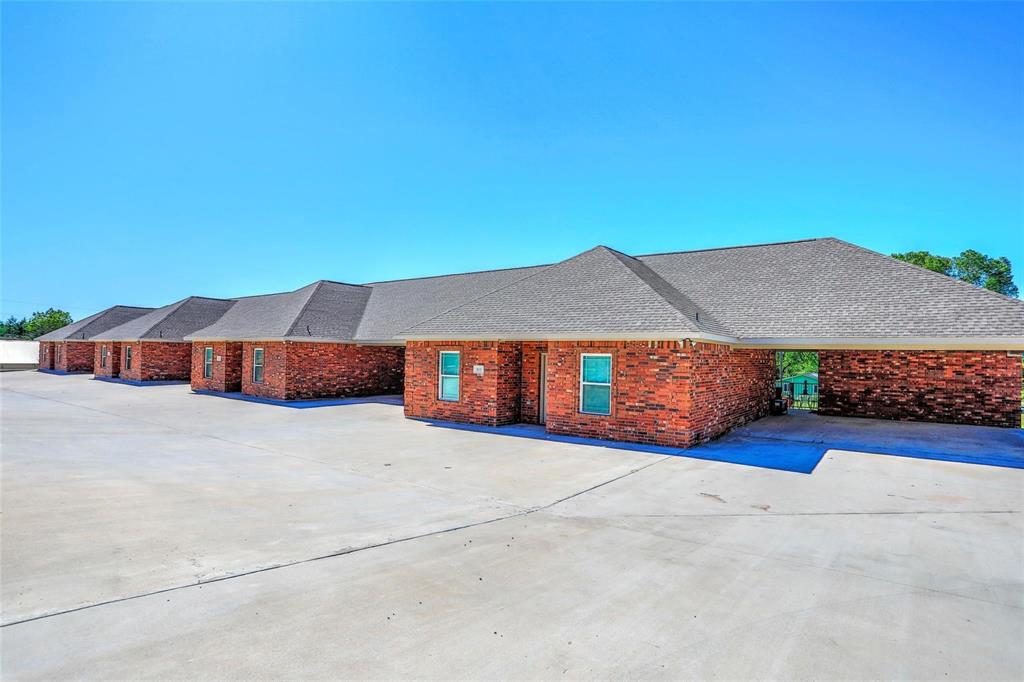 455 Neals Hill Road Oak Ridge, TX 76240 - Photo 3 of 19 View of front facade featuring a shingled roof, brick siding, and concrete driveway