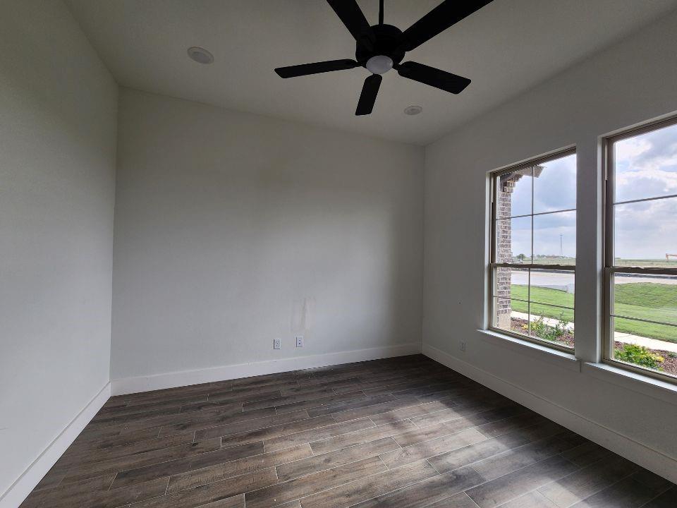 2408 Quartz Street Krum, TX 76249 - Photo 5 of 16 an empty room with a window and a fan