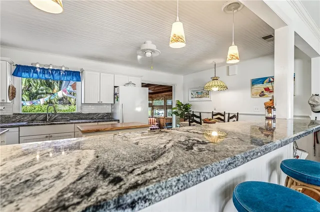 a living room with patio furniture and a floor to ceiling window